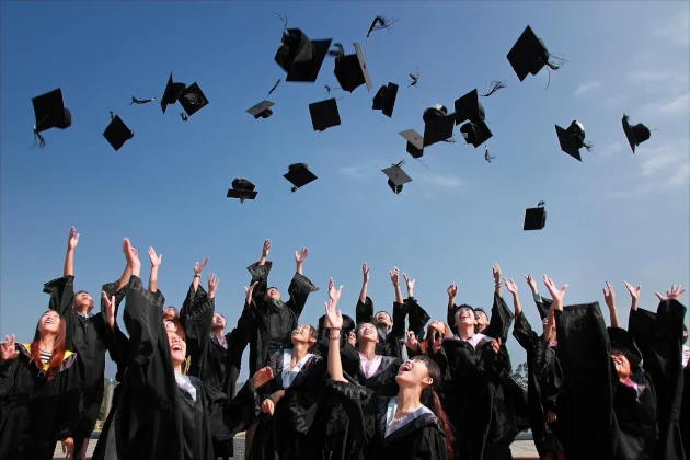 Graduates throwing cap into the air in celebration